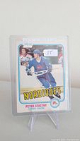 Front of Peter Stastny rookie card in protective case, showing him in Nordiques uniform, with rookie card label and $15 price sticker.