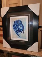 Full view of the professionally framed Don Chase "Blue Moon" print showing the black frame, white and black matting, with corner protectors.