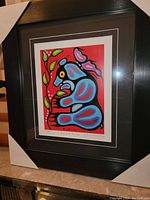 Full view of the professionally framed print 'Bear and Berries' depicting a stylized blue bear on red background with green leaves and a butterfly.