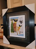 Photo of the professionally framed artwork showing two deer, with corner protectors on the frame.