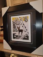 Framed artwork showing full view of Maud Lewis print and frame with protective corner guards.