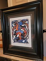 Photo of the professionally framed Tim Tait print showing the full artwork and frame from an angled front view.