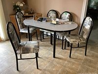 Image showing five chairs around a dining table with black metal frames and padded patterned seats.