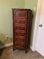 Front and side view of wooden lingerie chest showcasing all six drawers and carved bracket feet.