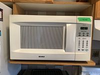 Front view of Kenmore white microwave with digital keypad and display, showing the overall size and condition.