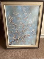 Full view of the framed painting showing textured flowers on branches against a misty blue-gray background with signature visible in the bottom right.