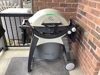 Front view of Weber Q grill on cart with base and wheels