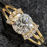 Front view of ring showing round moissanite and lab diamond accents on yellow gold split shank