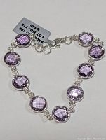 Full view of sterling silver pink amethyst bracelet photographed flat showing all stones and clasp.