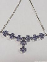 Close-up of the sterling silver chain and pendant with tanzanite stones, showing the front of the necklace against a white background.