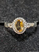 Close-up front view of sterling silver ring featuring an oval citrine gemstone set with decorative silver bead motifs.