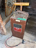 Full view of wooden case blasting machine with T-handle and cables laid on floor