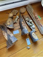 Overview of six carved wood pieces laid on a wooden surface, showing four wizards, owl, mushroom garden, and four additional wood pieces.