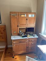 Overall front view of oak Hoosier-style cabinet with attached hutch