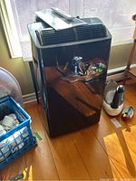 Front view of black Midea portable air conditioner with top vents