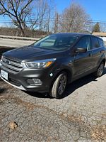 Front three-quarter view showing gray exterior, grille, headlight, alloy wheel and door panel