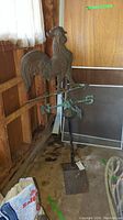 Full view of weathervane on stand showing rooster figure and directional arms