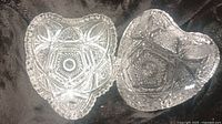 Two small 4-inch heart-shaped crystal dishes with intricate cut patterns