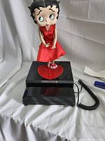 Front view of Betty Boop figurine on black phone base with red heart.
