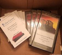 Photo shows five CD cases labeled 'The Foundations of Western Civilization Part 1 and Part 2' by Prof. Thomas Noble, some instructional booklets including a teaching compendium, all inside a cardboard box.