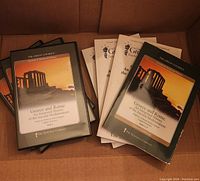 Stack of 18 audio CD cases and multiple guidebooks for 'Greece and Rome: An Intimate History of the Ancient Mediterranean' course by The Great Courses.