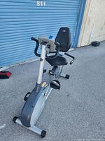 Front angled view of Nautilus recumbent exercise bike showing padded seat, backrest, pedals, and front handlebars.