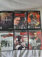 Front view of the six PlayStation 2 game cases arranged in two rows showing cover art from different game titles.