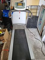 Full view of Precor 9.27 treadmill with running belt, handrails, and power cord on a tiled floor.