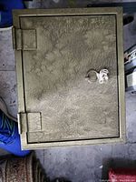 Exterior view of safe showing textured door with key lock and two hinges.
