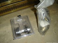 Two deadbolt locks with keys, one in plastic packaging and the other sealed in a plastic bag with accessories.