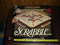Photo of Deluxe Edition Scrabble board game box showing game board image and branding.