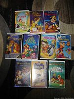 Photo showing 11 Disney VHS tapes with titles Bambi, Beauty and the Beast, Pinocchio, Lady and the Tramp, The Great Mouse Detective, The Jungle Book, Hercules, and others.