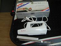Photo of Moulinex electric knife model 246 in white with original packaging box, power cord, and two blades with covers.