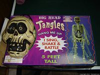 Box and skull head covering of Mr. Jangles skeleton decoration showing product branding, features, and condition
