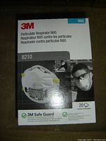 Box of 3M 8210 N95 particulate respirator face masks containing 20 masks, showing brand, model number, and usage images on the packaging.