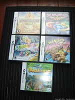 Five Nintendo DS game cases arranged in a black mesh holder showing front covers of Jewel Master Egypt, Bejeweled Twist, Nervous Brickdown, Slingo Quest, and Cradle of Rome.