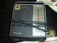 Front view of the Panasonic RF-563C AM/FM portable radio, showing speaker grille, tuning dial, and power indication.