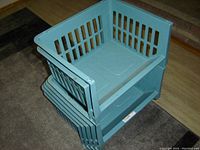 Five light blue plastic stackable storage bins shown stacked and resting on floor.