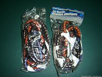 Photo shows two unopened packages of Orocal elastic tie downs. Each package contains six tie downs in different lengths (12, 18, 24 inch). The tie downs are multicolored elastic cords with metal hooks on each end.