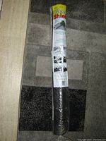 Photo of a rolled Weed Shield weed control landscaping fabric with clear product label and packaging showing approximate size and features.