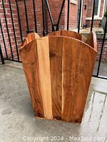 Front angle view of cedar planter showing vertical wood grain slats and scalloped edge top.