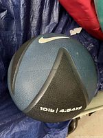 Medicine ball with Nike logo, showing weight of 10lb / 4.54kg and textured surface in black and dark blue color.