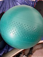 One green exercise yoga ball with dotted texture on circumference for grip.