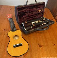 Photo of Woodstock C14 ukulele and open clarinet case with clarinet disassembled inside.