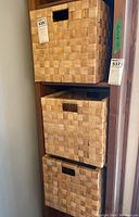 Three stacked woven collapsible crates showing checkerboard weave and handle cuts.