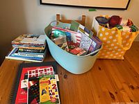 Overview photo of craft supplies including books, stickers, and yarn in containers on table