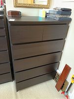 Front view of dark brown six-drawer dresser with flat top and minimalistic drawer fronts.