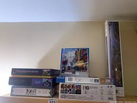 Jigsaw puzzle boxes stacked showing puzzle counts and themes