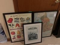 Photo showing all three framed prints grouped together: vegetable print, magazine page, and map of England.