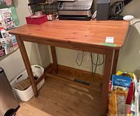 Front-left view of pub-height wooden table showing legs, lower brace and tabletop